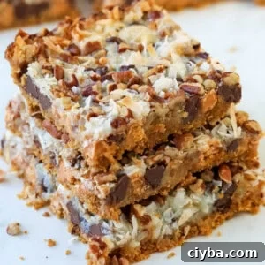 Three 7 layer magic cookie bars on top of each other.