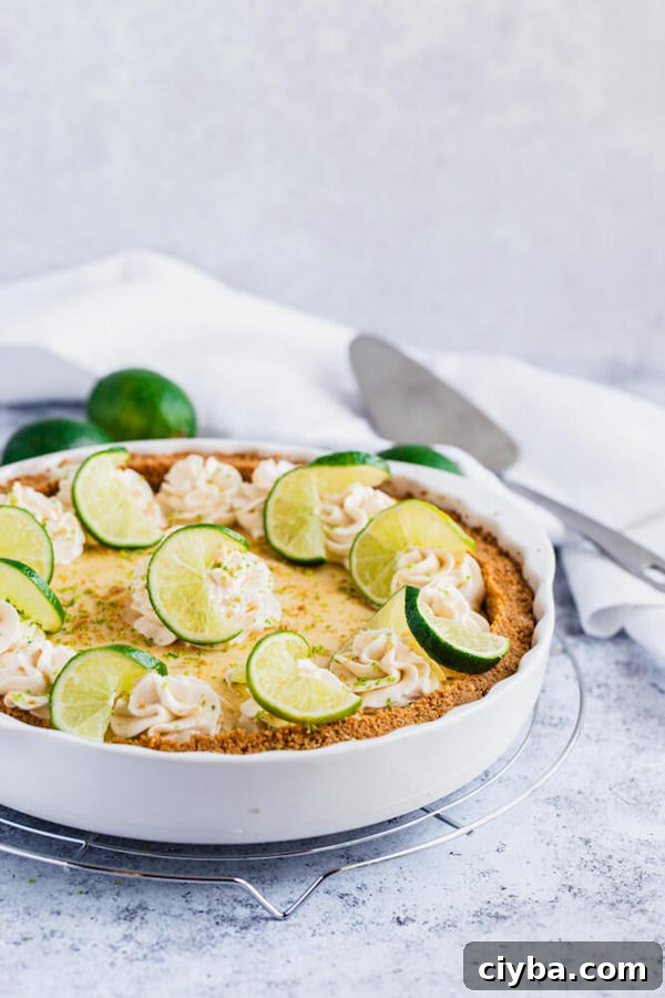 this key lime pie is made with a lime flavoured graham cracker crust, key lime pie filling and decorated with whipped cream, graham cracker crumbs, lime zest and lime twists