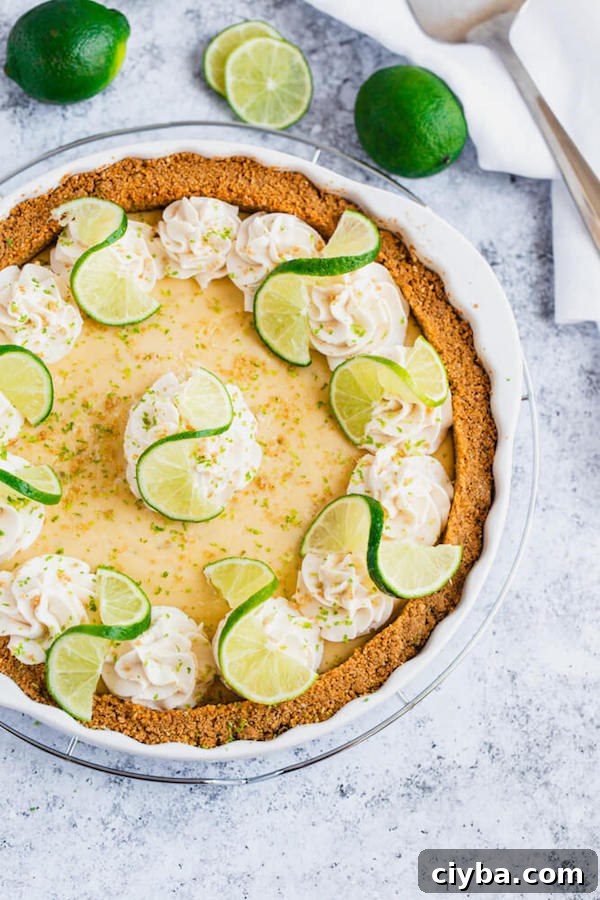 this key lime pie is made with a lime flavoured graham cracker crust, key lime pie filling and decorated with whipped cream, graham cracker crumbs, lime zest and lime twists