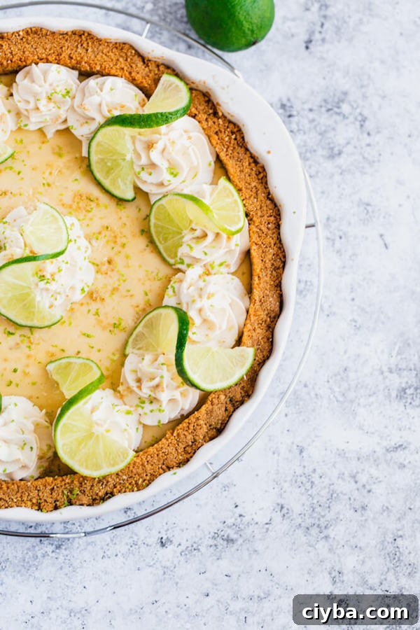 this key lime pie is made with a lime flavoured graham cracker crust, key lime pie filling and decorated with whipped cream, graham cracker crumbs, lime zest and lime twists