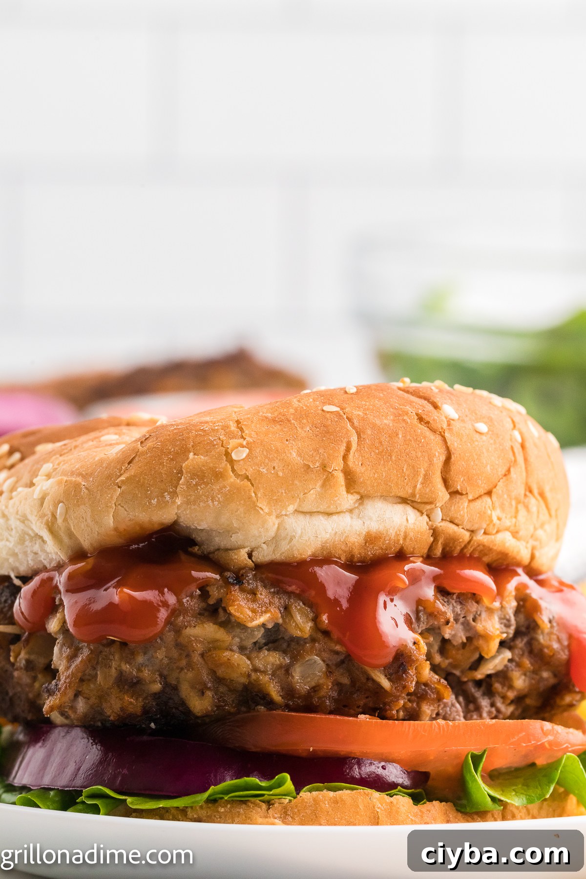 Meatloaf Burger on a plate layered with ketchup, slice tomatoes, and red onions