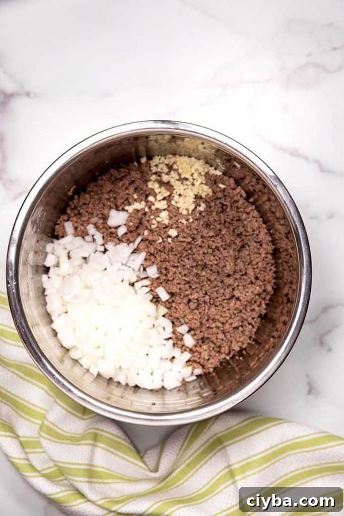 Instant Pot Texas Chili Recipe — Ready in 30 Minutes 6 cooked ground beef with chopped onions and minced garlic in an instant pot