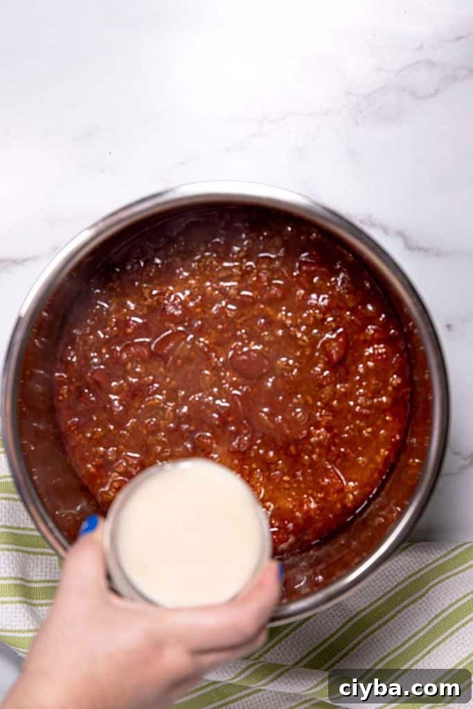 Instant Pot Texas Chili Recipe — Ready in 30 Minutes 9 pouring masa harina and water over the chili