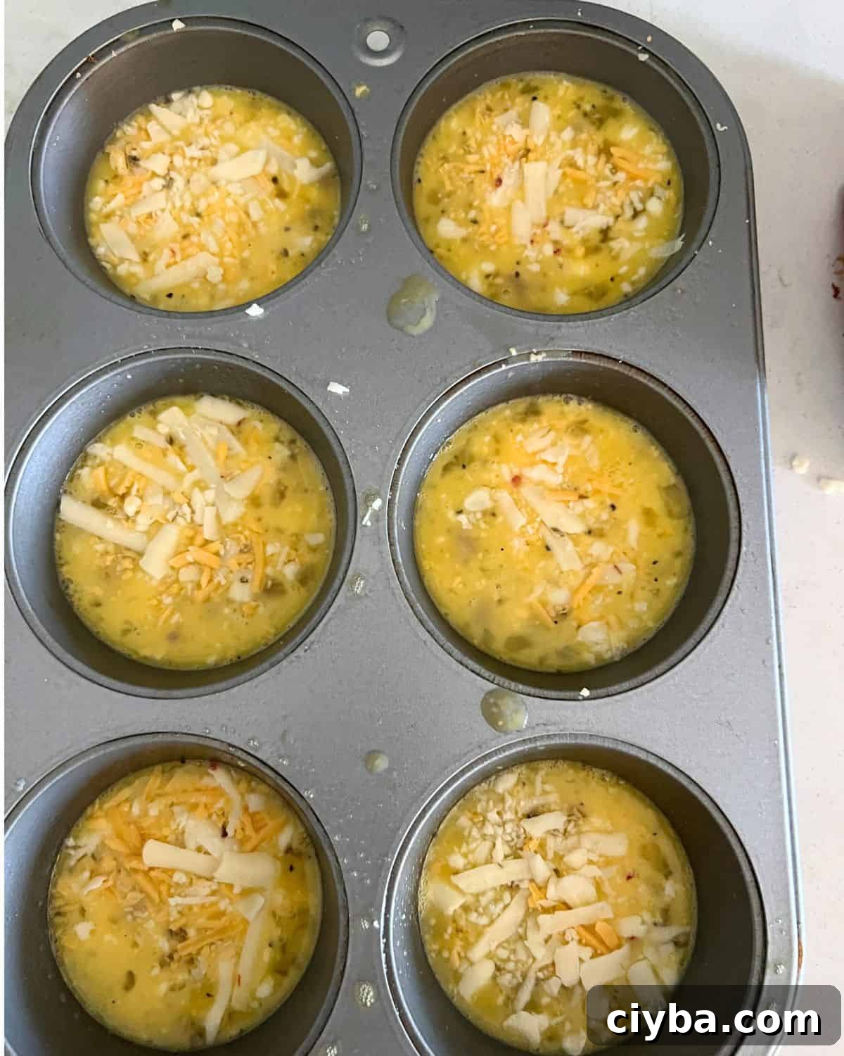 Egg mixture in a greased muffin pan. 