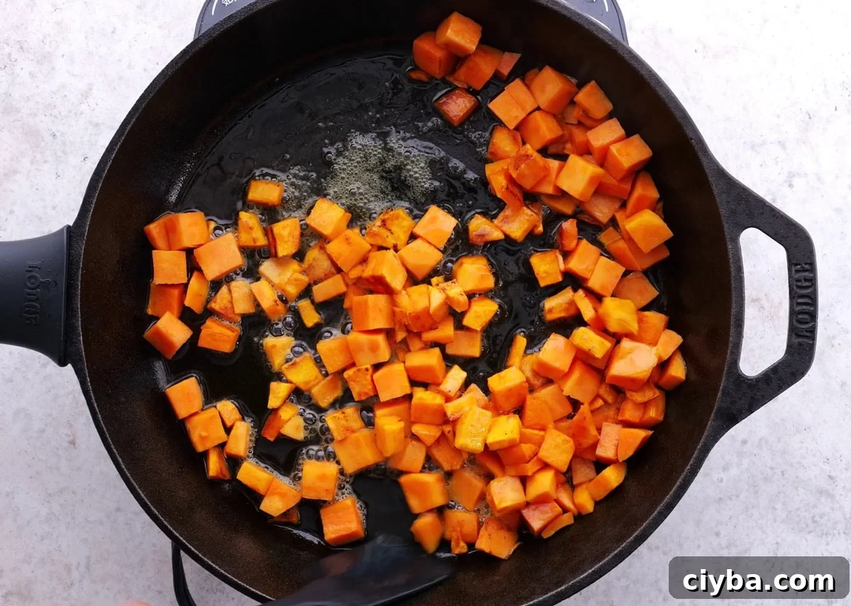 Sweet Potato and Black Bean Breakfast Tacos for Busy Mornings 4 Sweet potatoes cooking in a cast iron skillet.