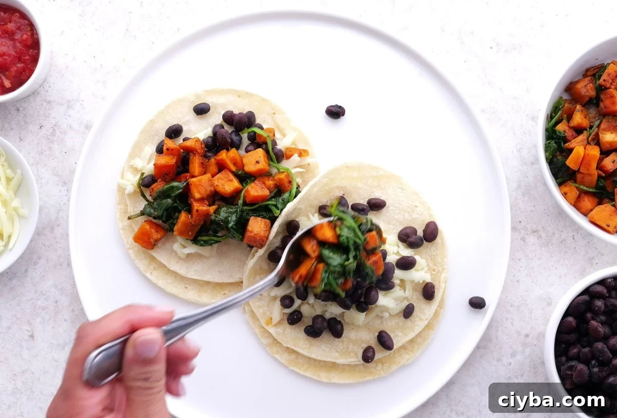 Sweet Potato and Black Bean Breakfast Tacos for Busy Mornings 7 Hand assembling breakfast tacos.