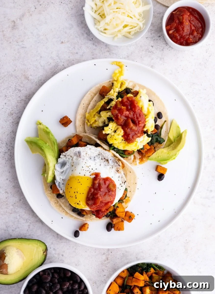 Sweet Potato and Black Bean Breakfast Tacos for Busy Mornings 9 Plate of sweet potato and black bean breakfast tacos with eggs and avocado on top, ready to eat.