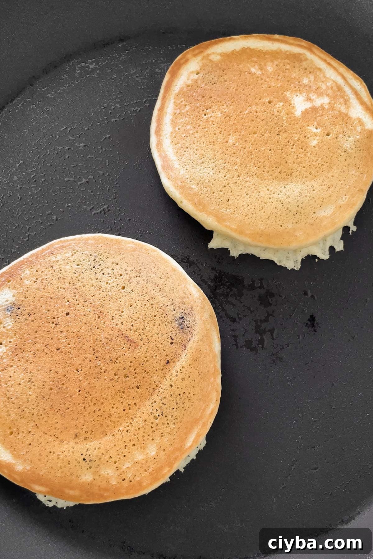 Process shot of the golden muffin mix pancakes after flipping in the skillet.
