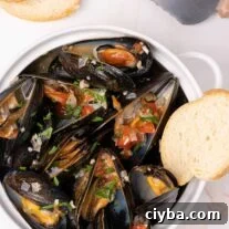 Italian-Style Steamed Mussels with Garlic, White Wine, and Herbs 5 Crock filled with steamed mussels topped with sautéed onion, garlic, diced tomatoes, and parsley.