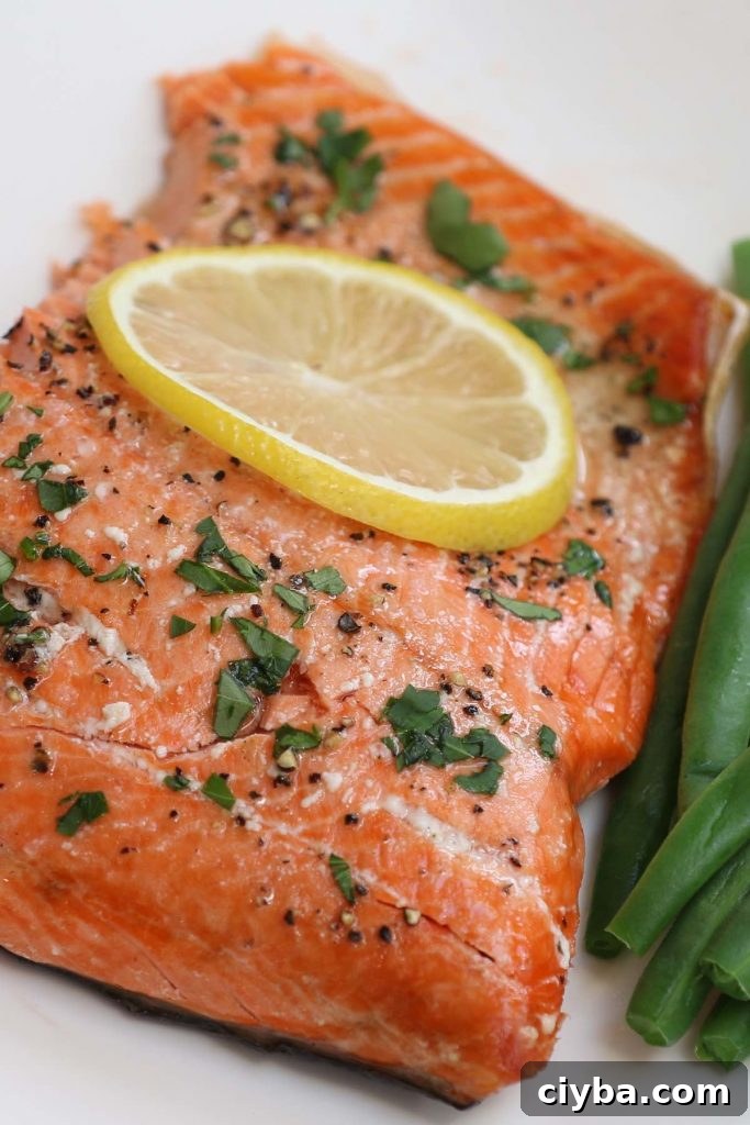 Sous vide salmon served with green beans on a white plate.