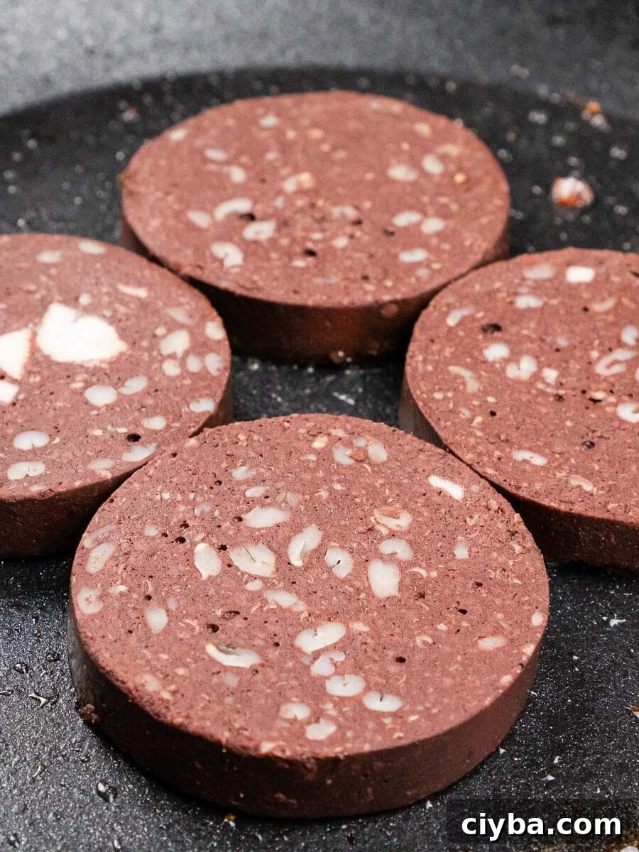 Four pieces of black pudding in a frying pan