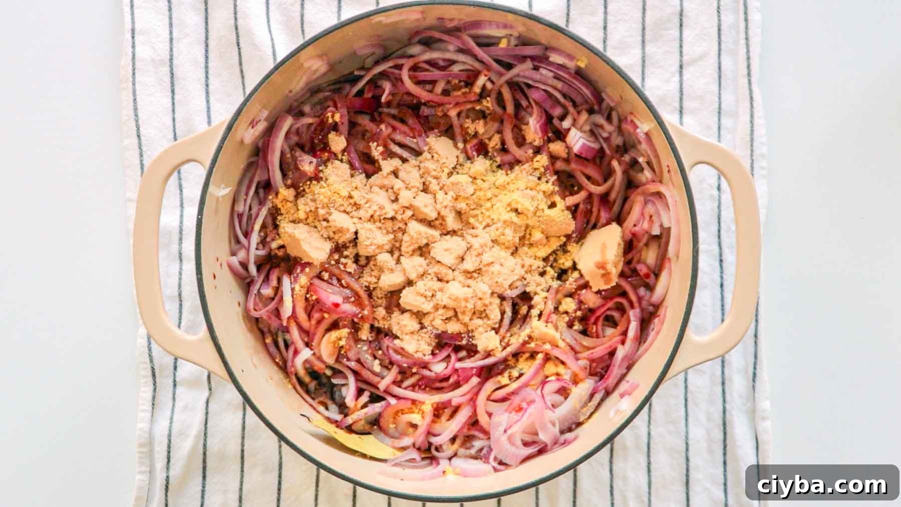 Caramelized red onions, brown sugar, and all the ingredients of the recipe in a dutch oven.
