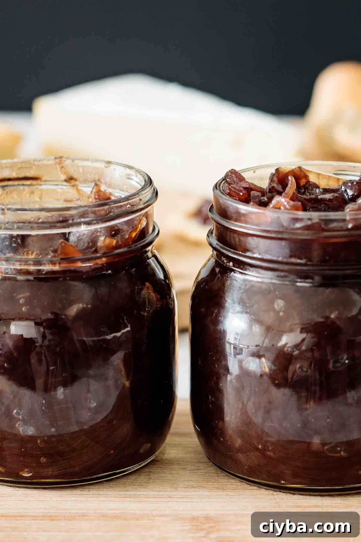 2 jars full of chutney over a wooden board.