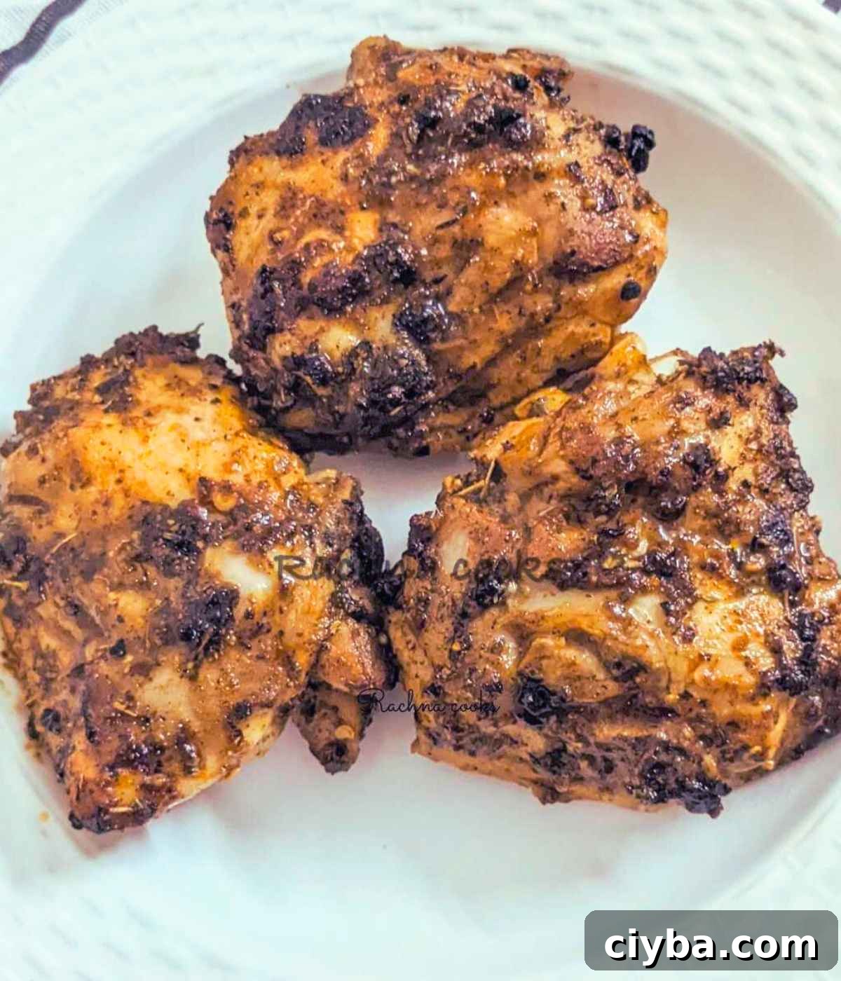 Close up of air fryer chicken thighs served on a plate.