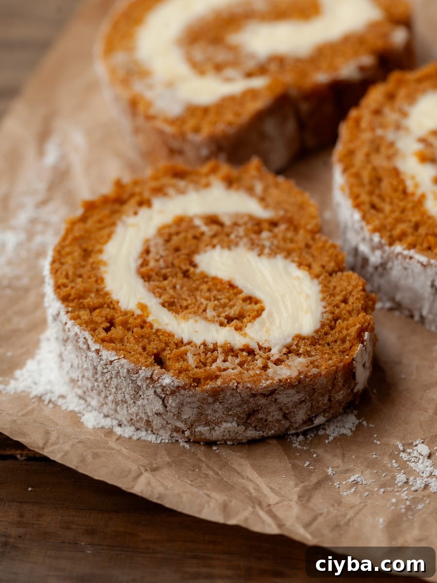 a sliced gluten free pumpkin cake roll on a brown parchment paper