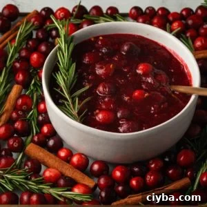 brandy cranberry sauce with gold spoon and garnished with rosemary