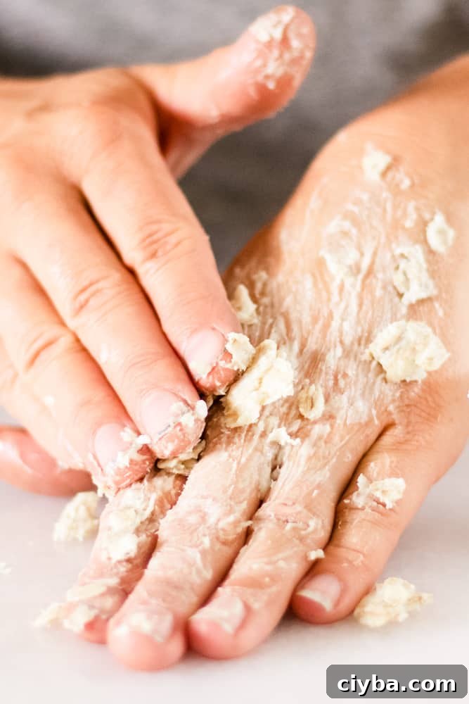 Massaging the hand mask into dry cracked hands.