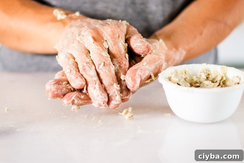 Bowl of oatmeal hand mask sitting next to hands covered lotion.