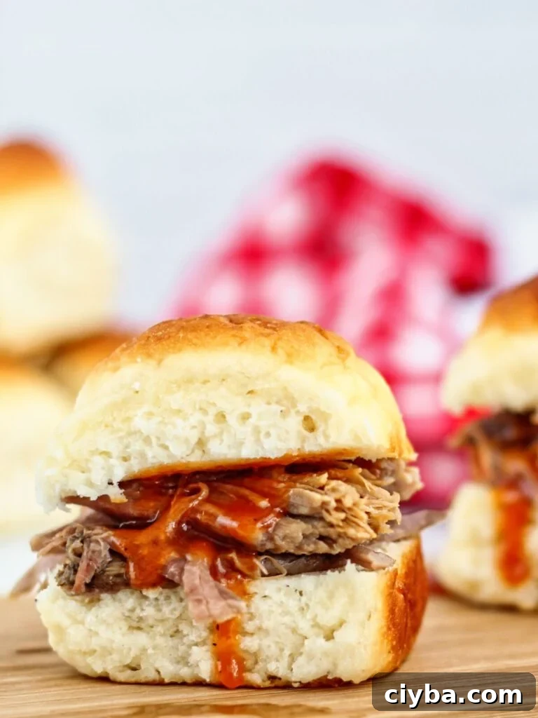 kahlua pork sliders on wooden cutting board with red checked napkin in the background.