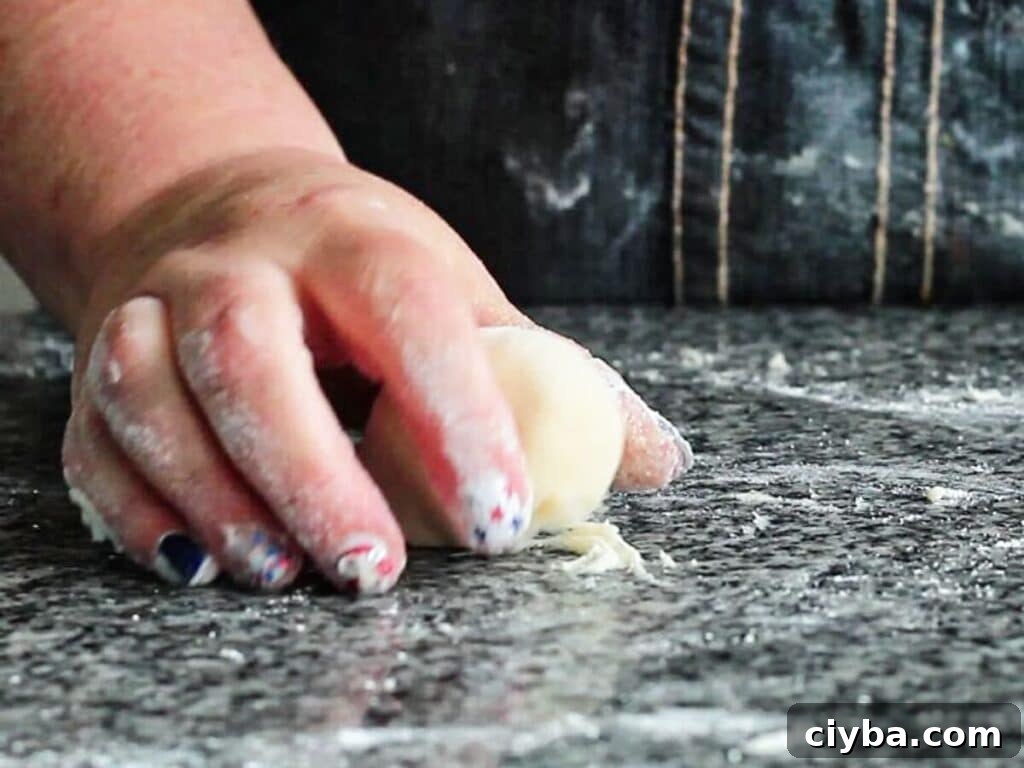 rolling dough using cupped hand to create a tight ball.