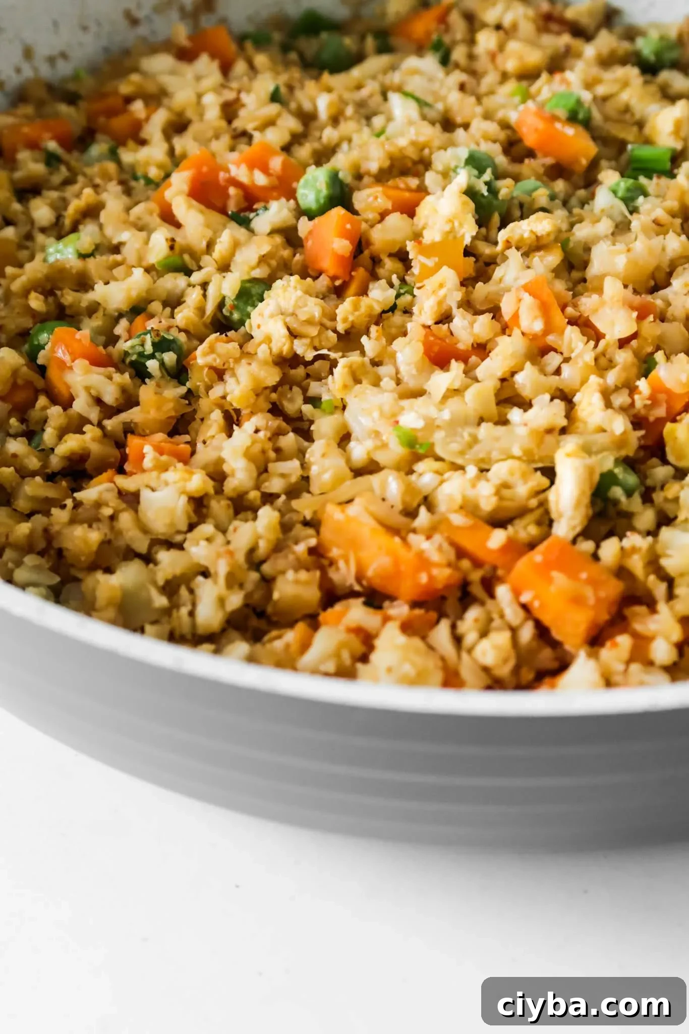 Easy cauliflower fried rice recipe! You’ll need cauliflower, eggs, tamari or soy sauce, vegetables of choice and some oil to make this vegetarian low carb recipe from scratch! Only 30 minutes and you’ll have a delicious, filling and healthy dinner on the table! This clean eating recipe is gluten-free, dairy-free, vegetarian and low carb and comes with an easy meal prep option. #healthy #recipe #easy #dinner #easydinner #cauliflower #friedrice #lowcarb #lowcarbdinner