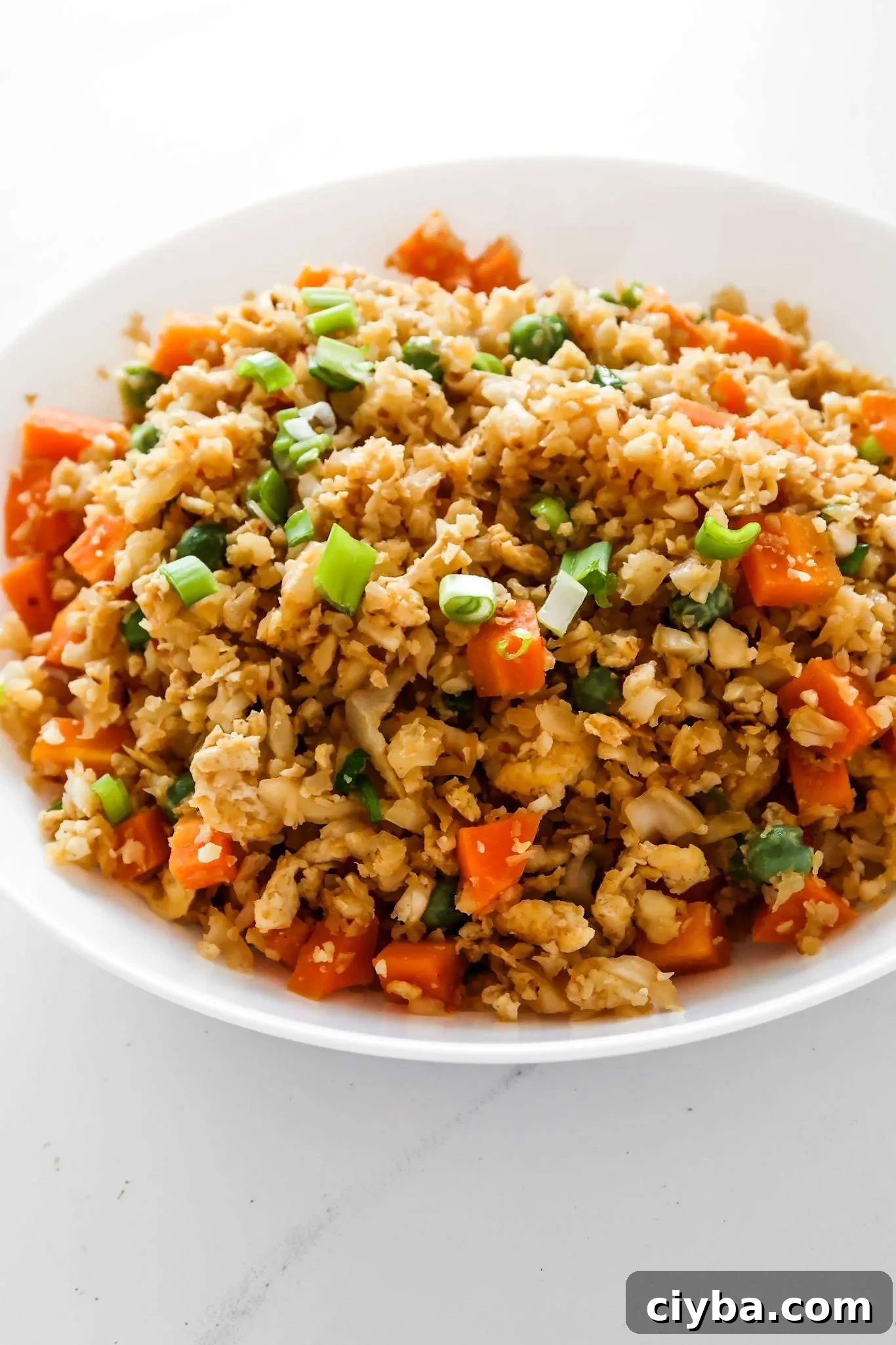 Easy cauliflower fried rice recipe! You’ll need cauliflower, eggs, tamari or soy sauce, vegetables of choice and some oil to make this vegetarian low carb recipe from scratch! Only 30 minutes and you’ll have a delicious, filling and healthy dinner on the table! This clean eating recipe is gluten-free, dairy-free, vegetarian and low carb and comes with an easy meal prep option. #healthy #recipe #easy #dinner #easydinner #cauliflower #friedrice #lowcarb #lowcarbdinner