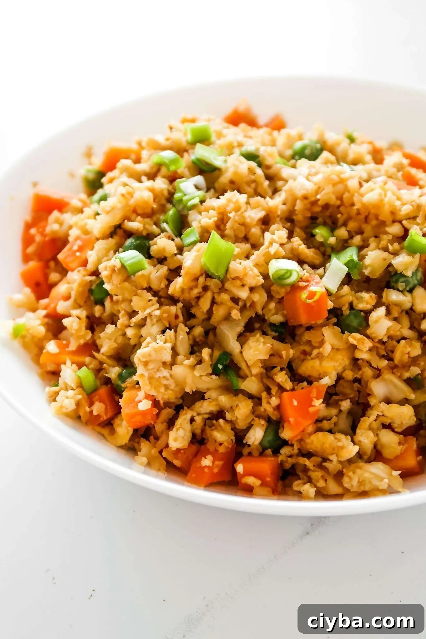 Easy cauliflower fried rice recipe! You’ll need cauliflower, eggs, tamari or soy sauce, vegetables of choice and some oil to make this vegetarian low carb recipe from scratch! Only 30 minutes and you’ll have a delicious, filling and healthy dinner on the table! This clean eating recipe is gluten-free, dairy-free, vegetarian and low carb and comes with an easy meal prep option. #healthy #recipe #easy #dinner #easydinner #cauliflower #friedrice #lowcarb #lowcarbdinner