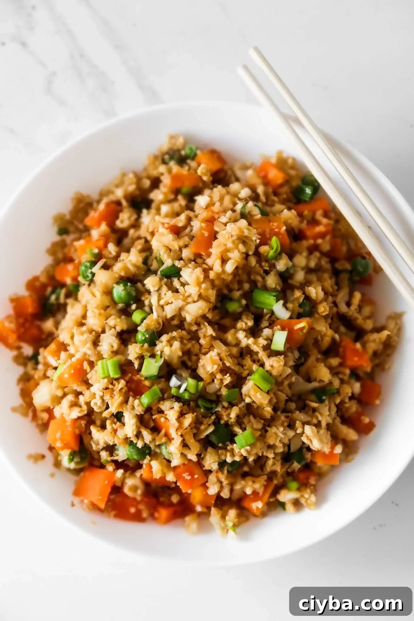 Easy cauliflower fried rice recipe! You’ll need cauliflower, eggs, tamari or soy sauce, vegetables of choice and some oil to make this vegetarian low carb recipe from scratch! Only 30 minutes and you’ll have a delicious, filling and healthy dinner on the table! This clean eating recipe is gluten-free, dairy-free, vegetarian and low carb and comes with an easy meal prep option. #healthy #recipe #easy #dinner #easydinner #cauliflower #friedrice #lowcarb #lowcarbdinner