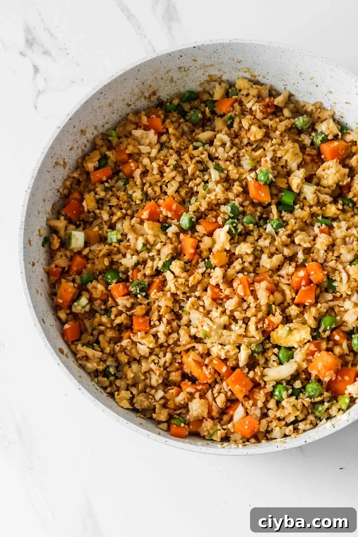 Easy cauliflower fried rice recipe! You’ll need cauliflower, eggs, tamari or soy sauce, vegetables of choice and some oil to make this vegetarian low carb recipe from scratch! Only 30 minutes and you’ll have a delicious, filling and healthy dinner on the table! This clean eating recipe is gluten-free, dairy-free, vegetarian and low carb and comes with an easy meal prep option. #healthy #recipe #easy #dinner #easydinner #cauliflower #friedrice #lowcarb #lowcarbdinner