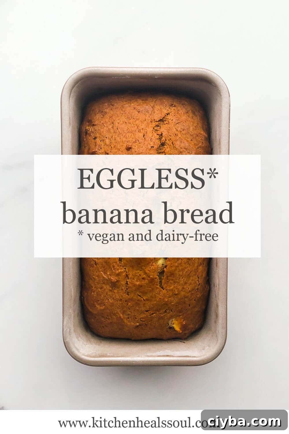 Loaf of eggless banana bread (vegan and dairy-free) in loaf pan on marble surface