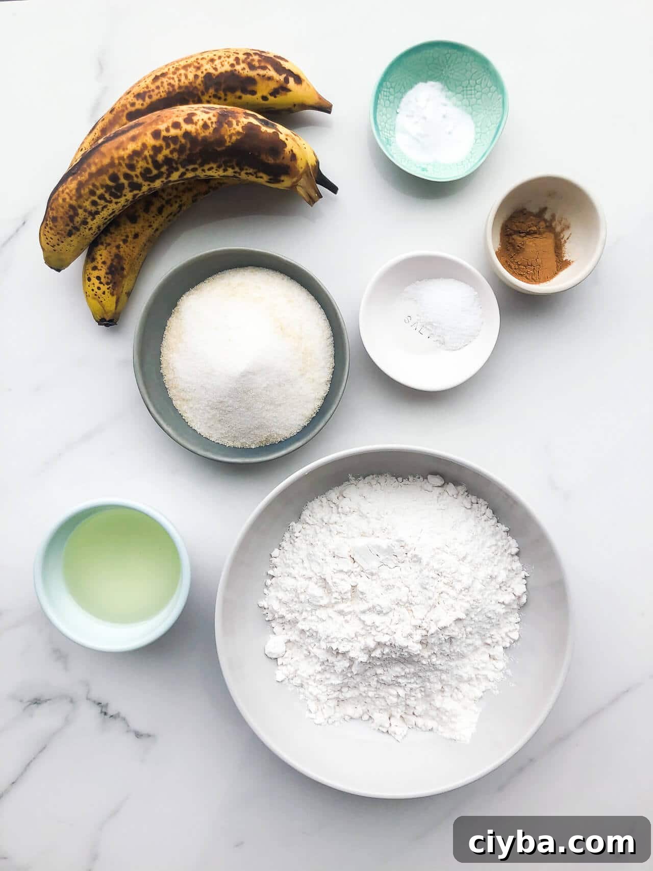 Bowls of ingredients for vegan banana bread (eggless and dairy-free) include oil, bananas, sugar, flour, baking soda, salt, cinnamon