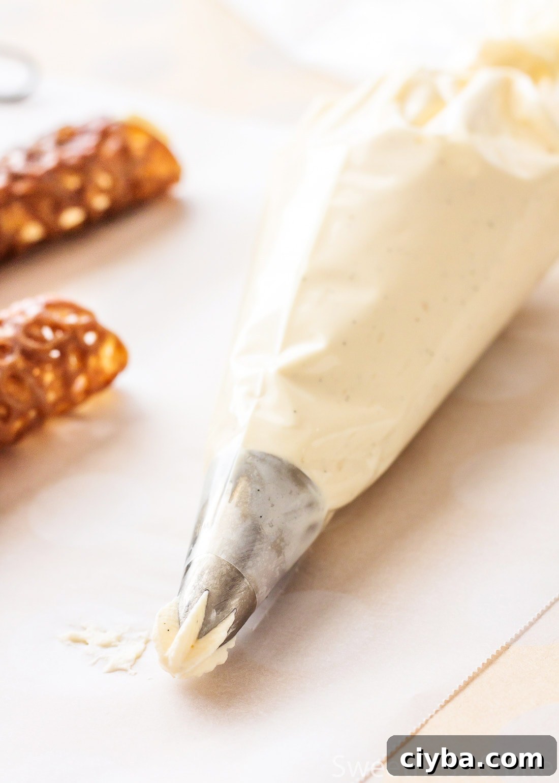 Close up of a piping bag fitted with a star piping tip and filled with whipped cream.