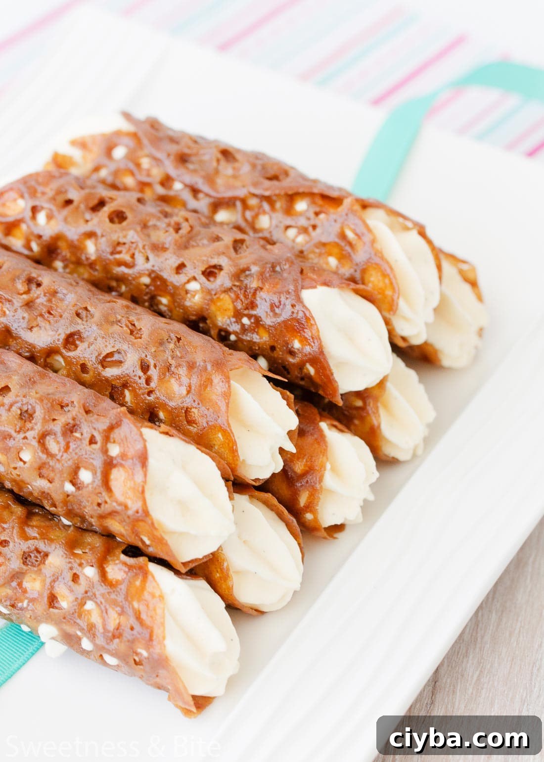 A plate stacked high with cream-filled brandy snaps.
