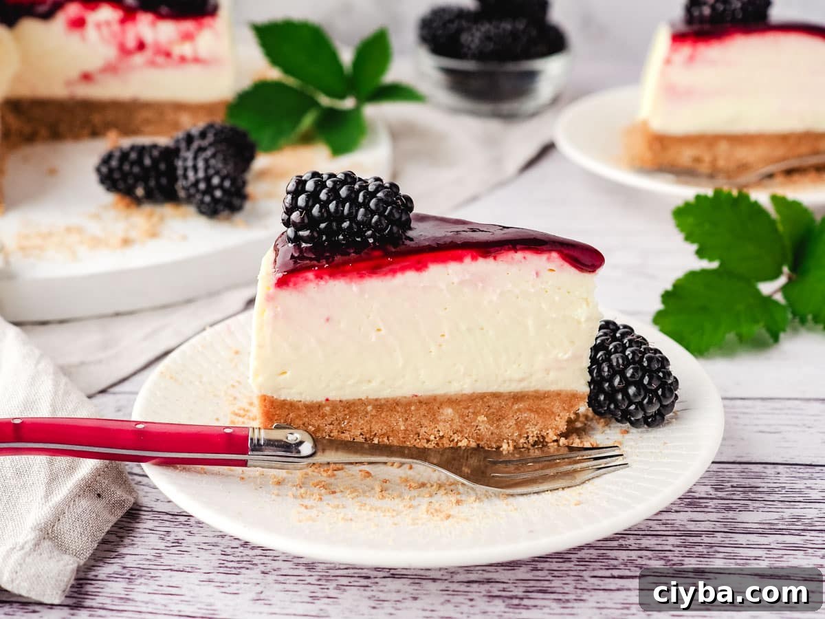 Slice of no bake blackberry cheesecake on a plate with fork, and rest of cake in background.