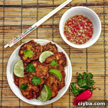 A plate of thai salmon fishcakes next to a bowl of spicy dipping sauce.