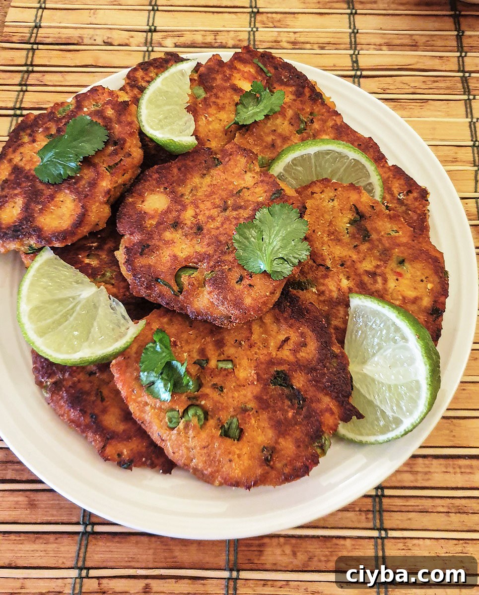 Thai Salmon Fish Cakes with Spicy Lime Dipping Sauce 3 A plate of Thai salmon fishcakes garnished with slices of lime and coriander.