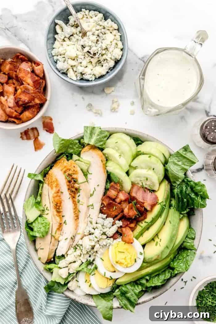 overhead view of keto cobb salad next to bowls of bacon, cheese, and dressing