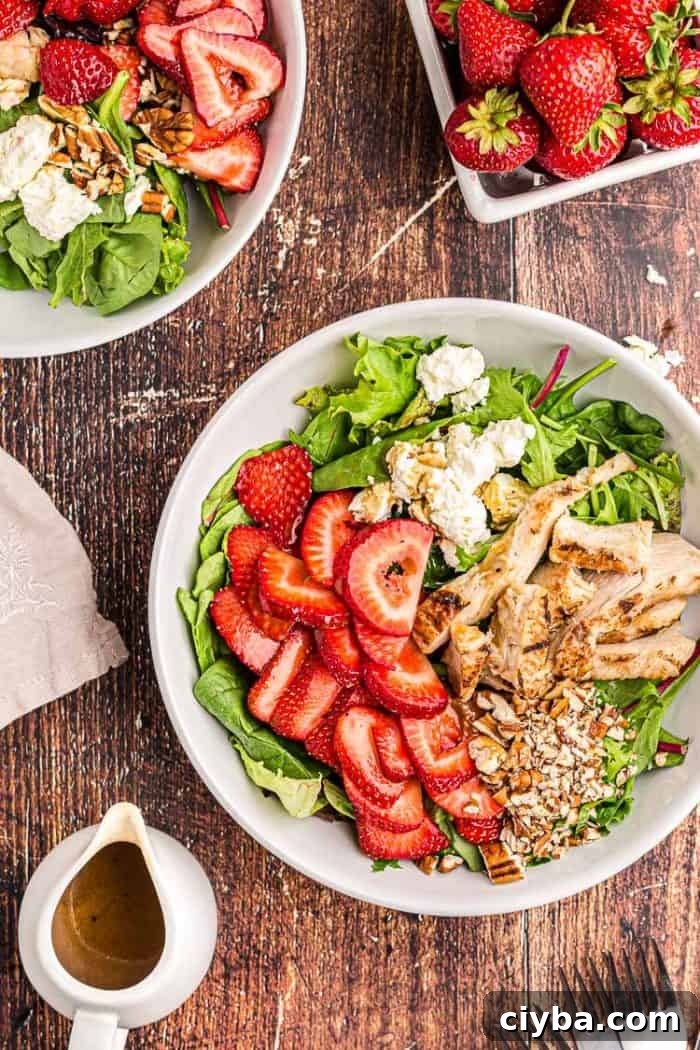 overhead view of keto strawberry chicken salad next to a bowl of fresh strawberries