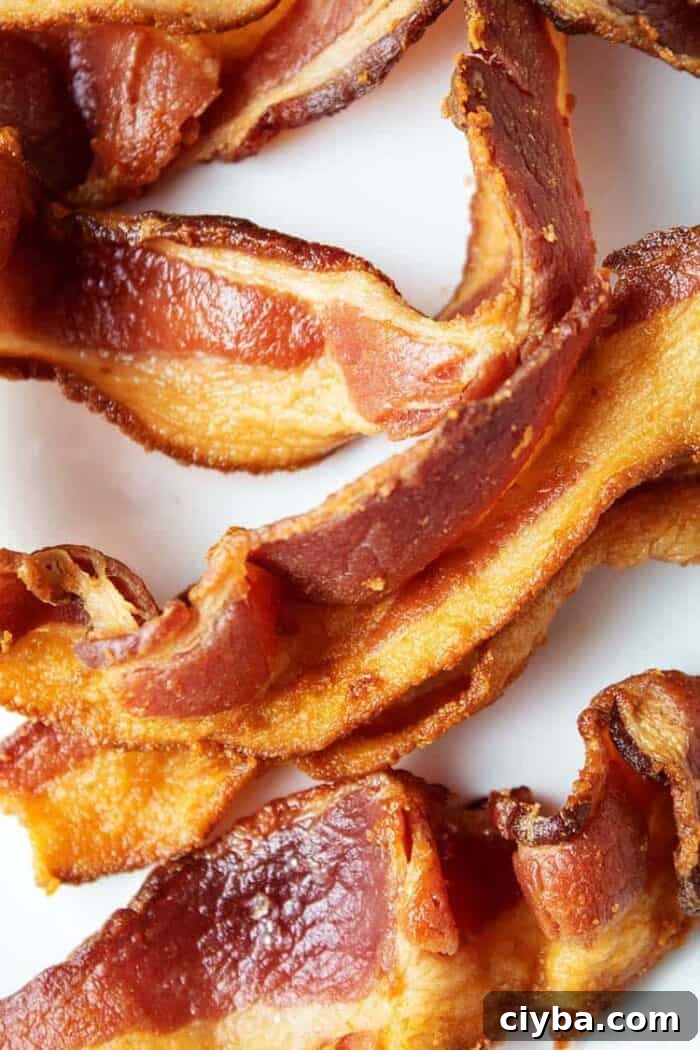 closeup of several slices of keto air fryer bacon in a white plate