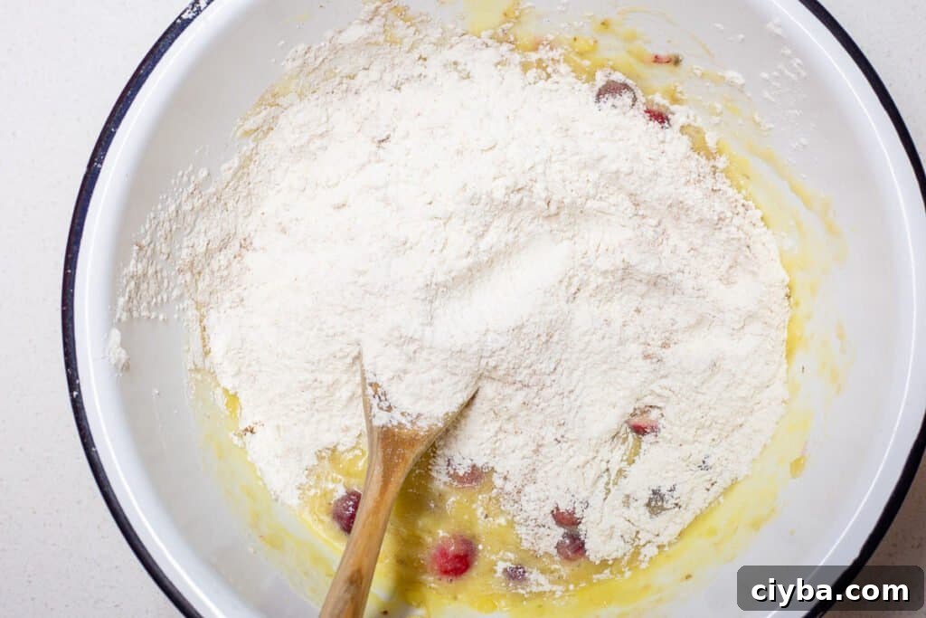 Next step in recipe of adding in flour mixture to wet mixture.