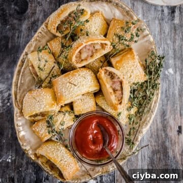 Gluten-Free Sausage Rolls with Homemade Pastry Recipe 23 sausage rolls on a plate with a bowl of ketchup