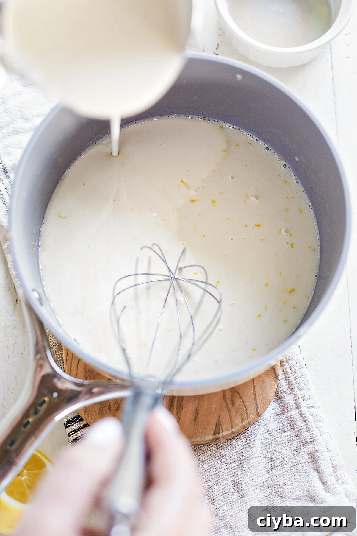 woman making lemon panna cotta in a saucepan