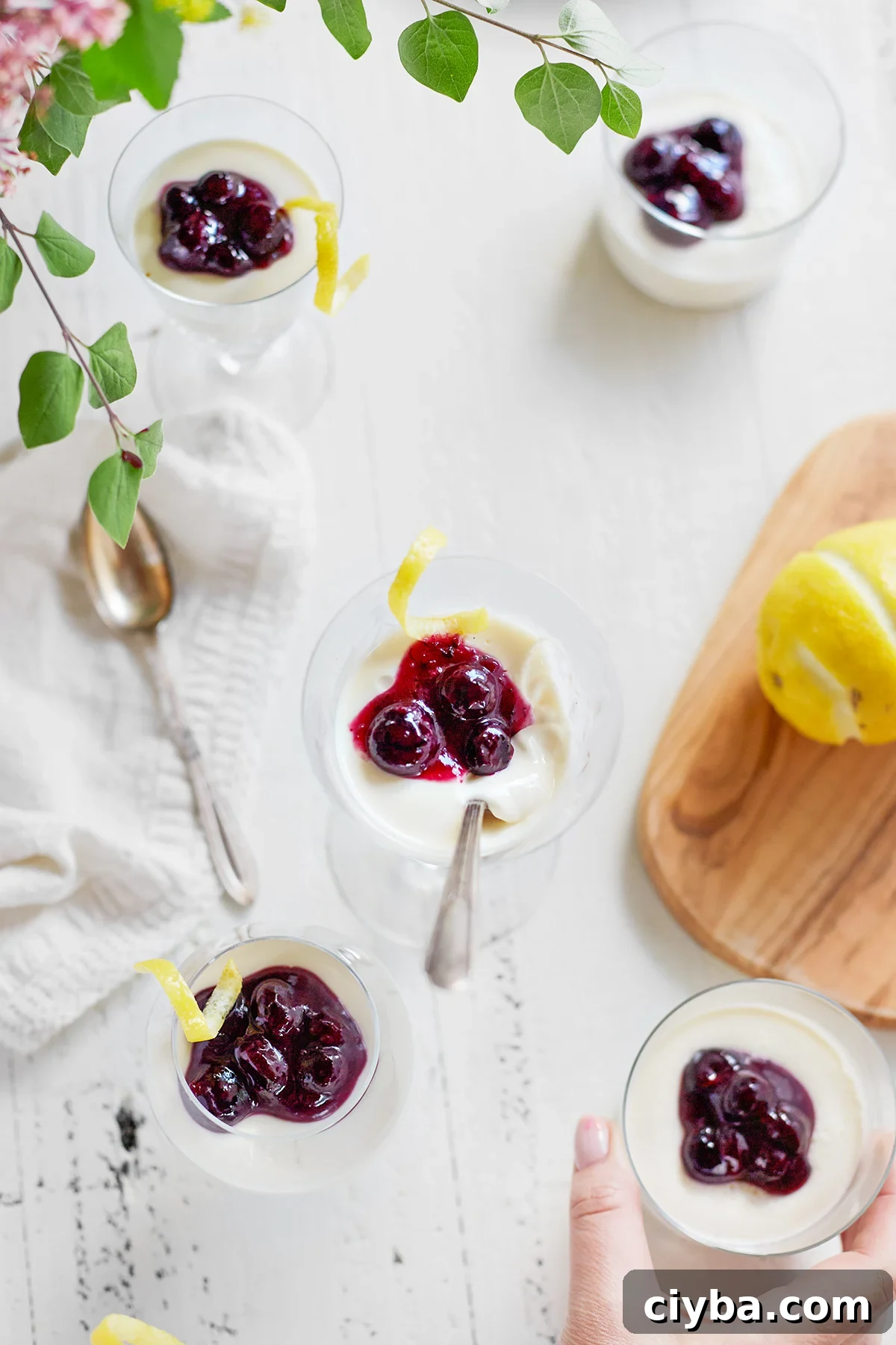 woman picking up a dish of blueberry lemon panna cotta