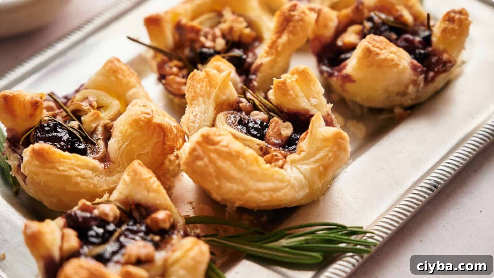 A tray of cranberry brie bites with walnut topping.