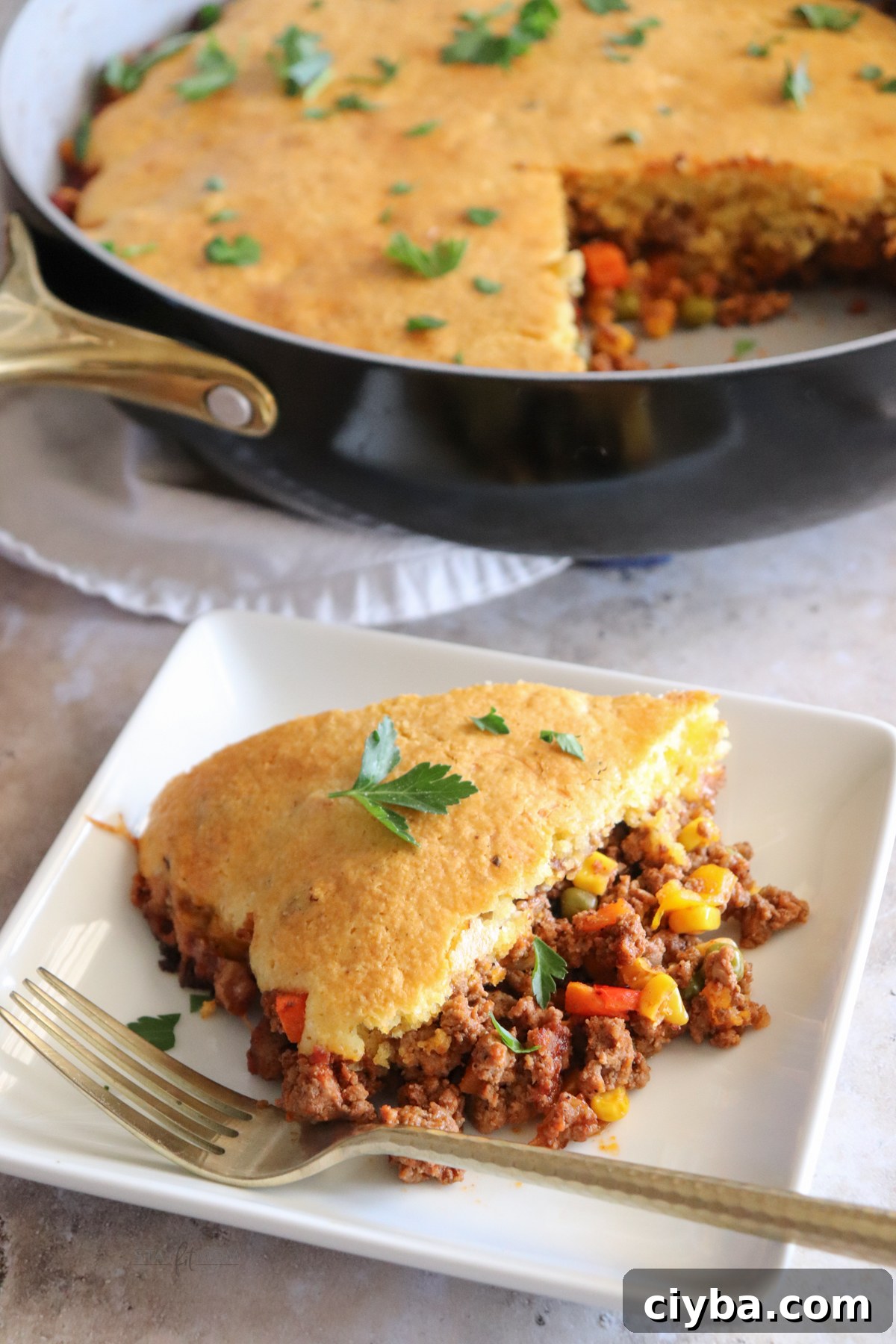 Hearty Cowboy Cornbread Casserole Bake 2 Cowboy Cornbread Casserole showing a slice of the meal with the pan in the background.