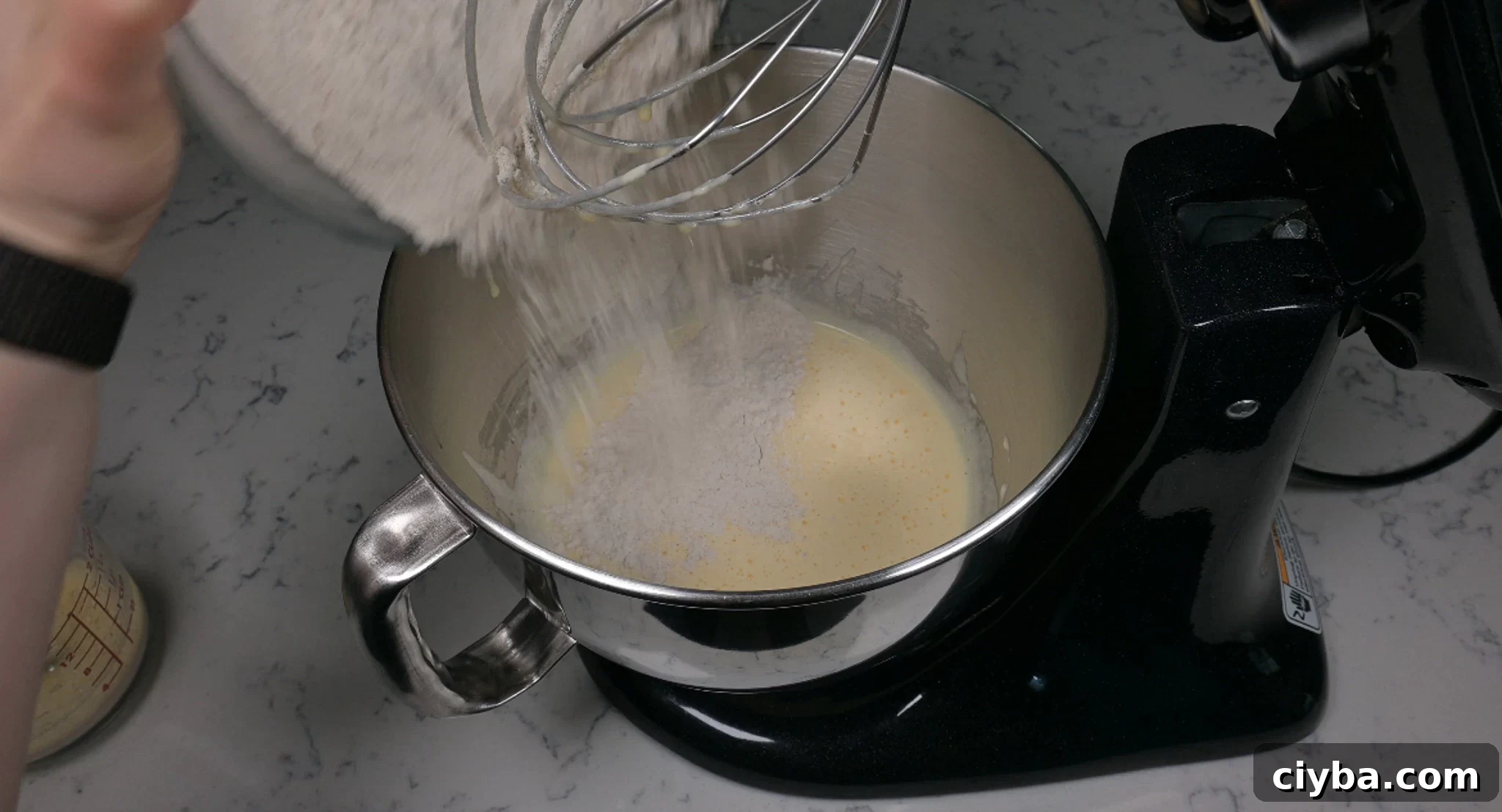 Adding in dry ingredients to the batter.
