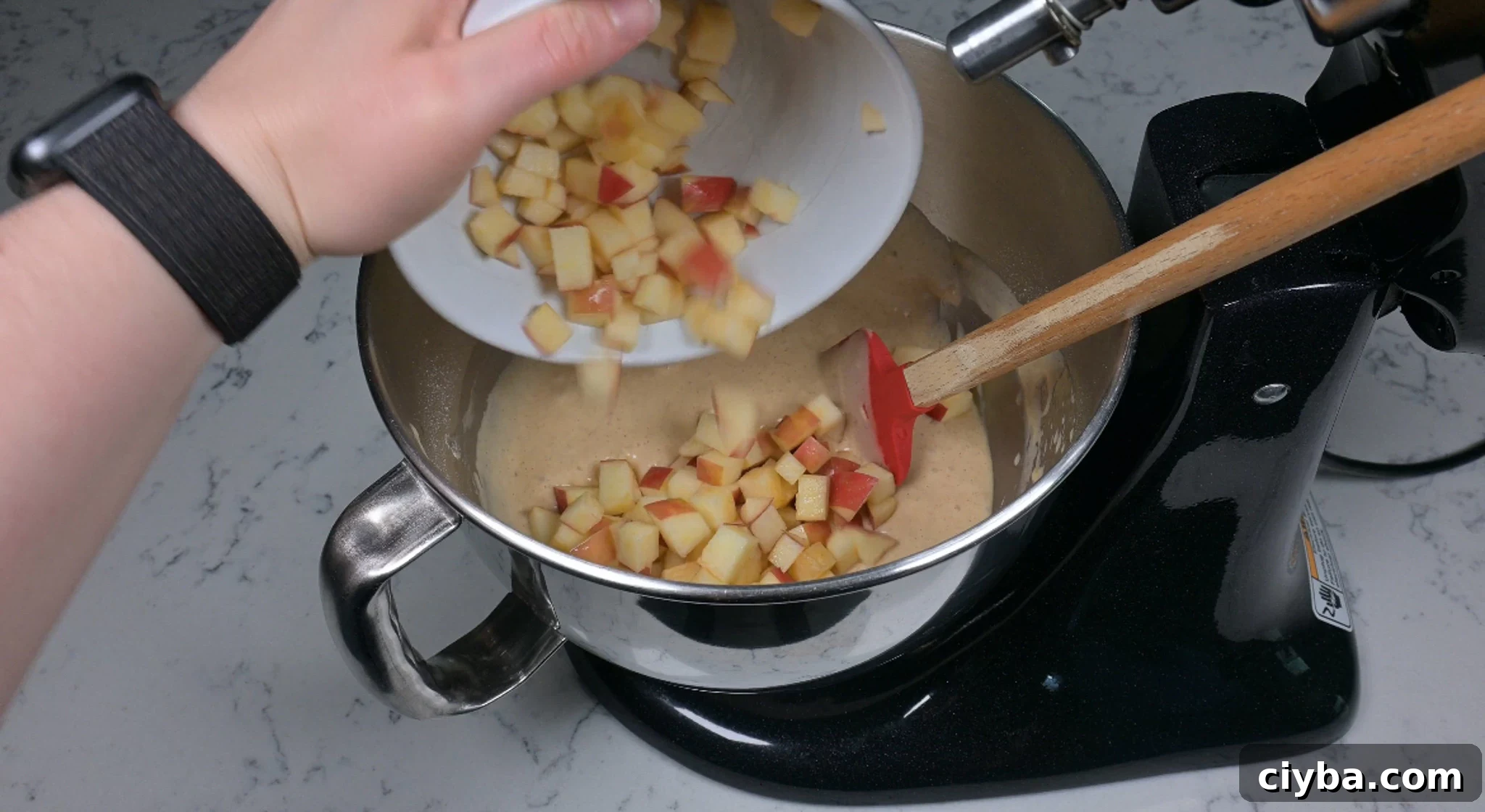 Adding in chopped apple to the batter.