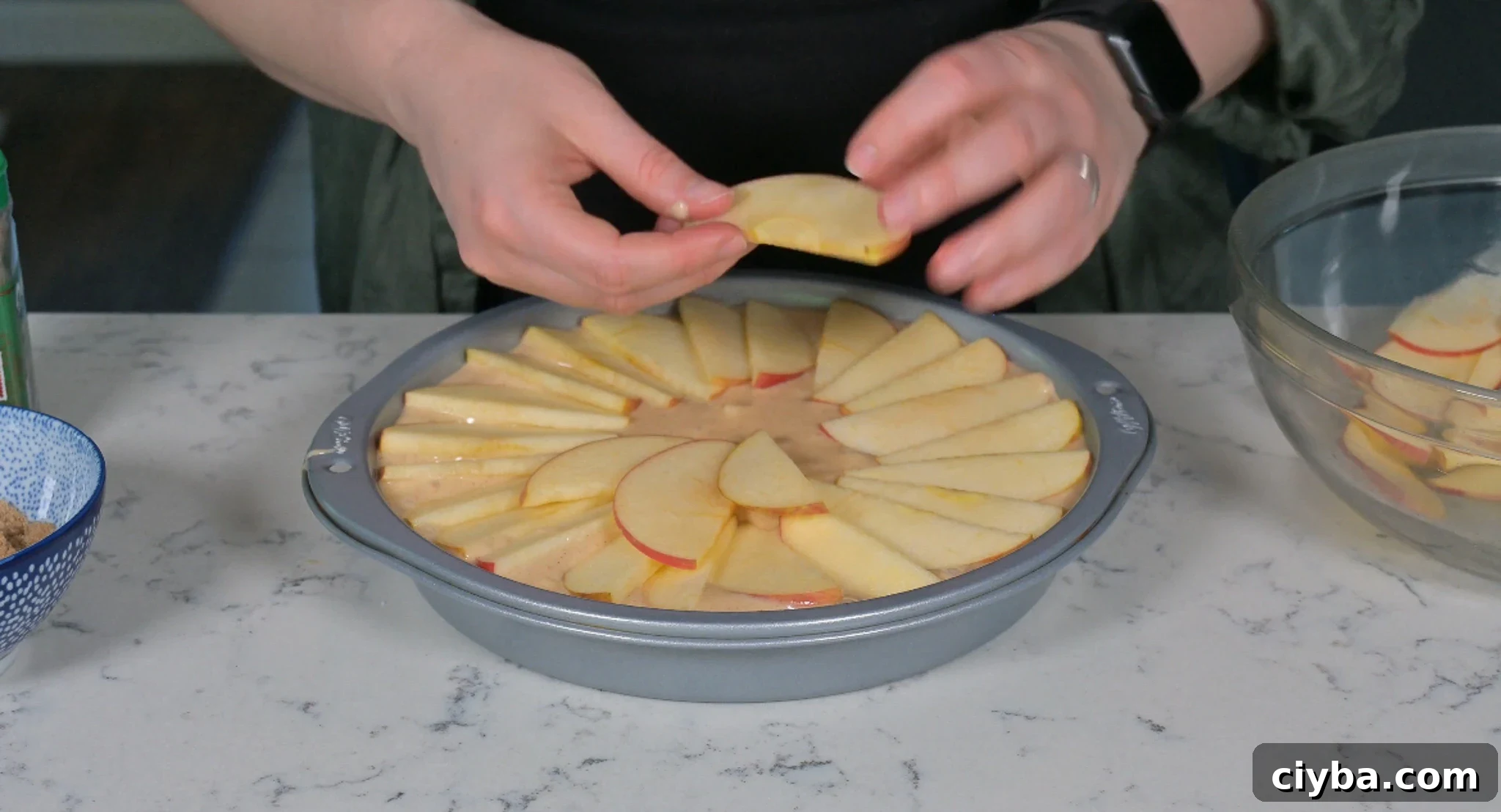 Arranging apples on the cake.