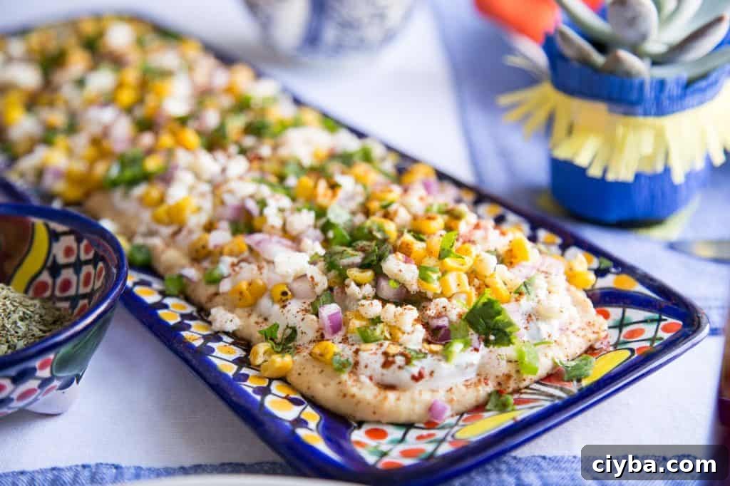 Creamy Mexican Street Corn Dip Recipe for Parties 3 elote dip on a colorful rectangular dish.