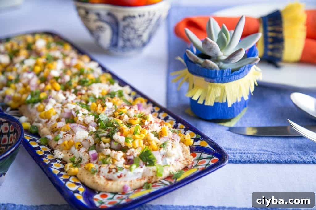 Creamy Mexican Street Corn Dip Recipe for Parties 7 mini succulent next to a platter of mexican street corn dip.